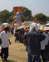 the procession begins with the top of the pyre removed to allow it to pass under the electric cables